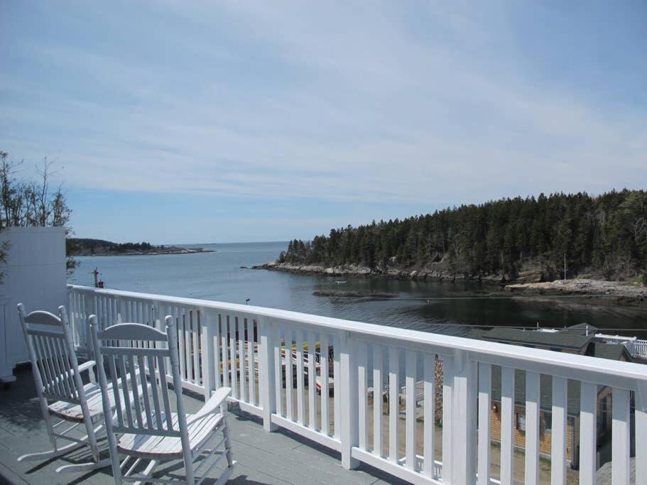 2 Stühle auf einem Balkon mit Blick auf das Wasser in der Unterkunft Phenomenal Home on Coast of Maine in Phippsburg