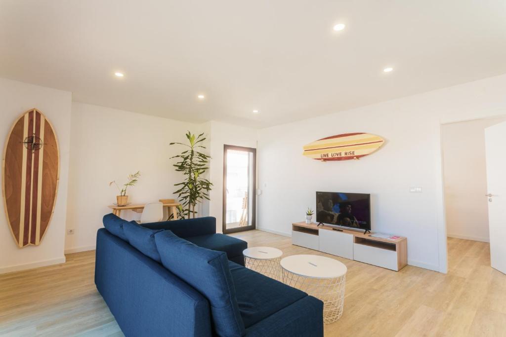 a living room with a blue couch and a tv at Best Houses 29 - Apartamento das Vinhas in Peniche