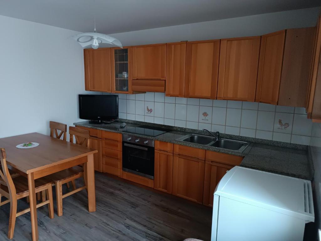 素蒂歐的住宿－Appartamento della Nonna，厨房配有木制橱柜、桌子和冰箱。