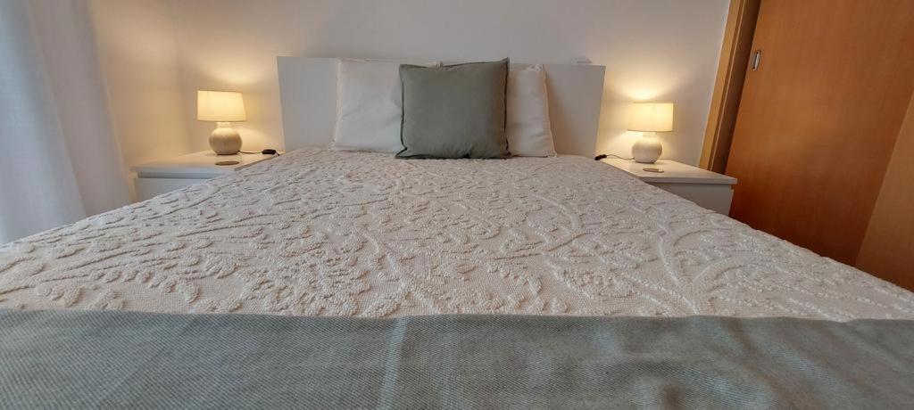 1 dormitorio con 1 cama blanca y 2 lámparas en Zise Flor-de-Lis, en Conceição