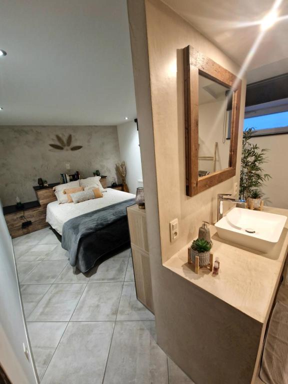 een slaapkamer met een bed, een wastafel en een spiegel bij Le Twenty in Marche-en-Famenne