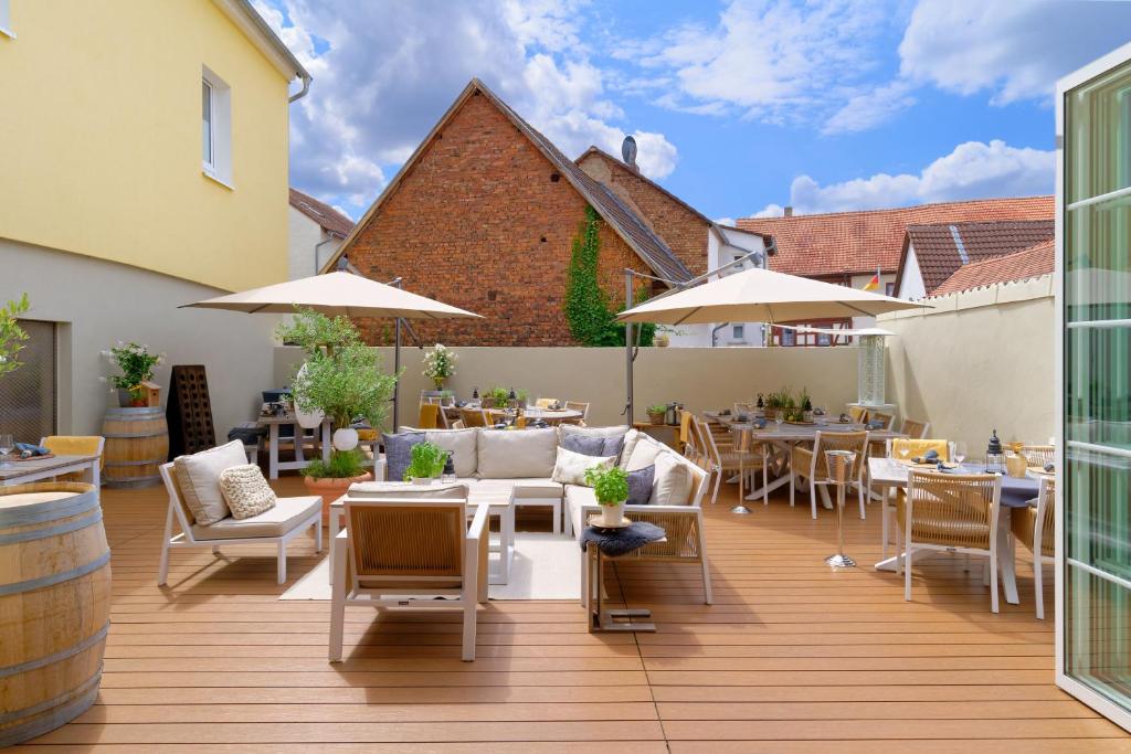 eine Terrasse mit Tischen, Stühlen und Sonnenschirmen in der Unterkunft Hotel Krone in Alzenau in Unterfranken