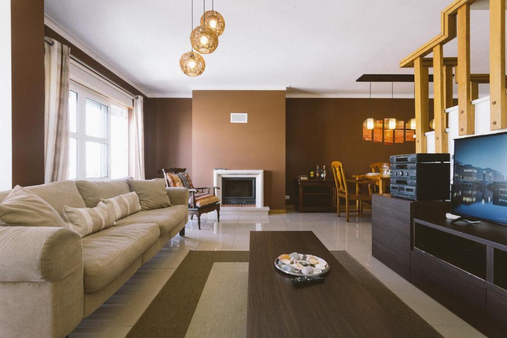 ein Wohnzimmer mit Sofa und Fernseher in der Unterkunft Best Houses 34 - West Sea House in Ferrel