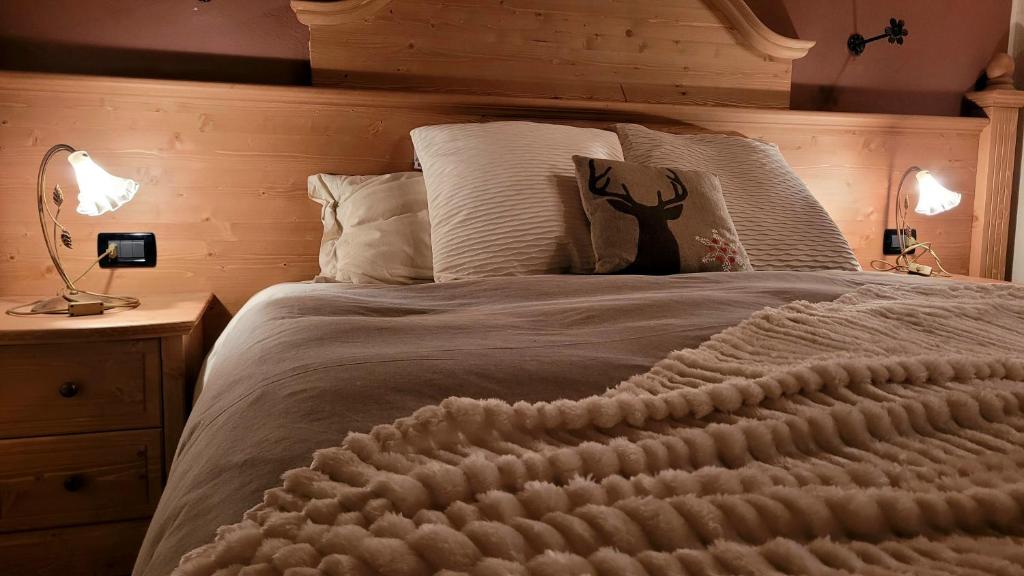 een slaapkamer met een groot bed met een houten hoofdeinde bij BAITA 2 LOVELY AND CENTRAL SAUZE D'OULX in Sauze dʼOulx