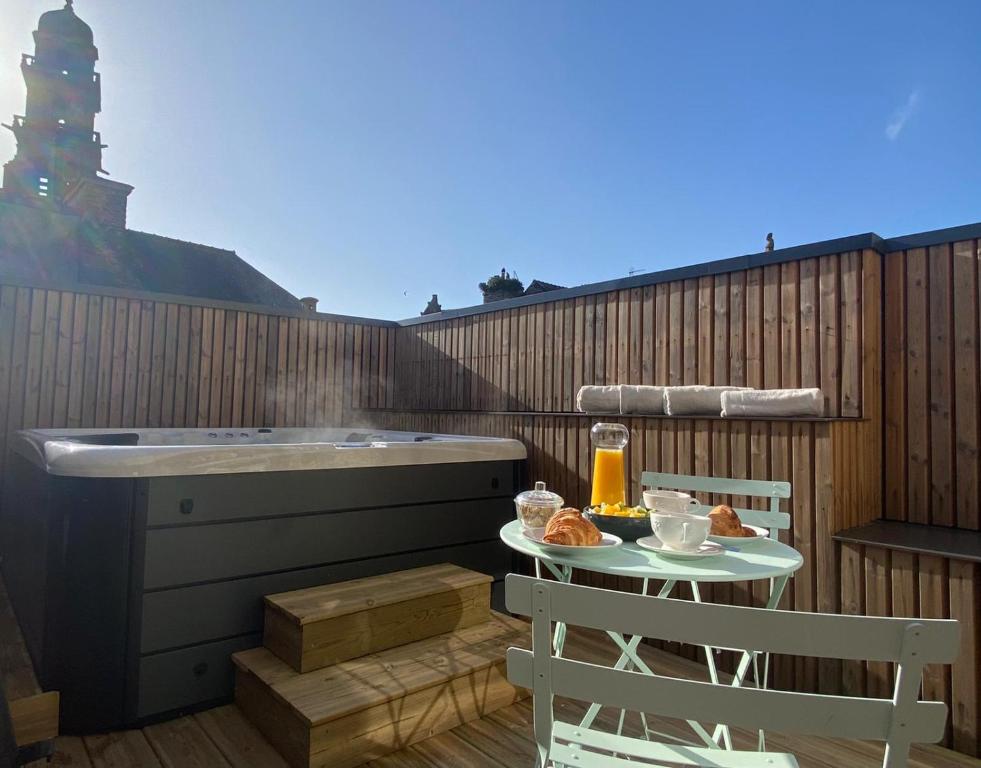 a patio with a hot tub and a table and chairs at La Maison du Quai Triplex de charme 4 étoiles en hyper centre avec SPA in Landerneau