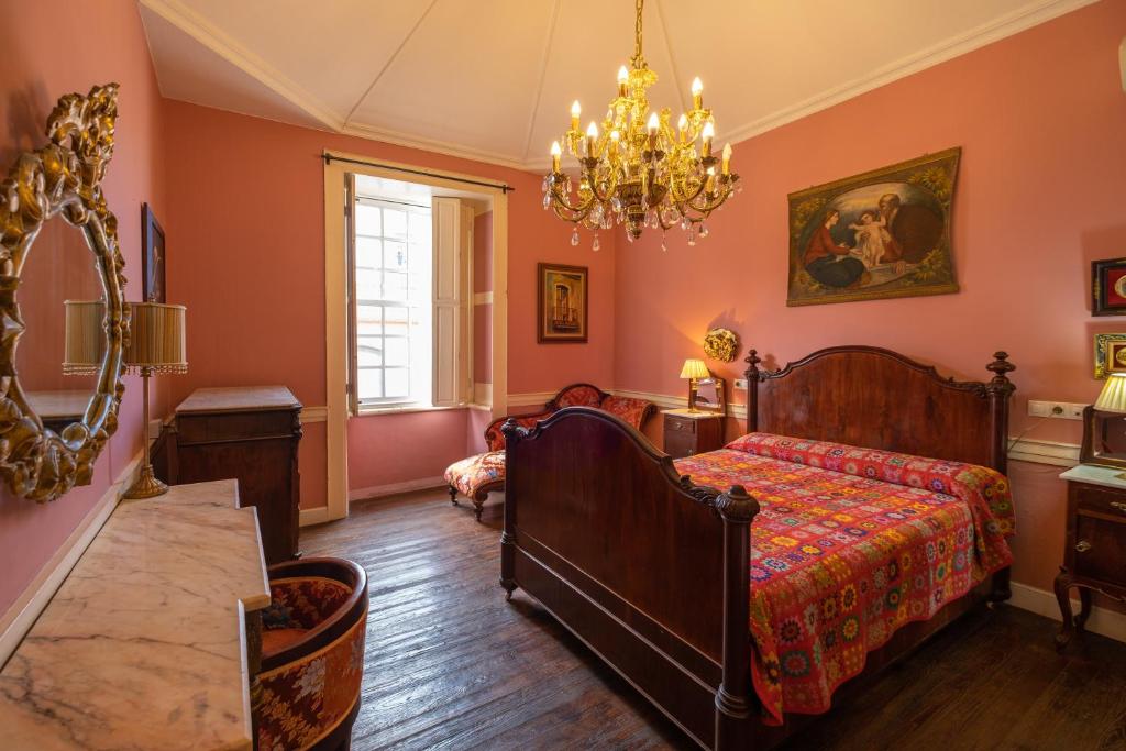 1 dormitorio con cama y lámpara de araña en Casa Jurado, en El Paso