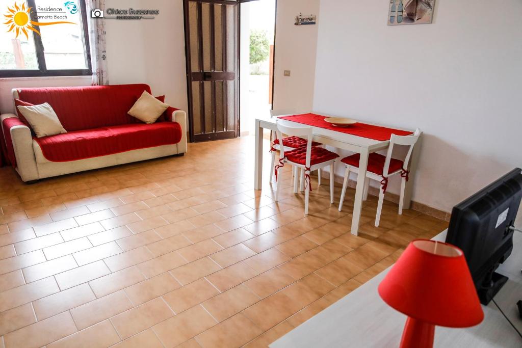 a living room with a red couch and a table at Cannotta Beach - Lipari in Terme Vigliatore