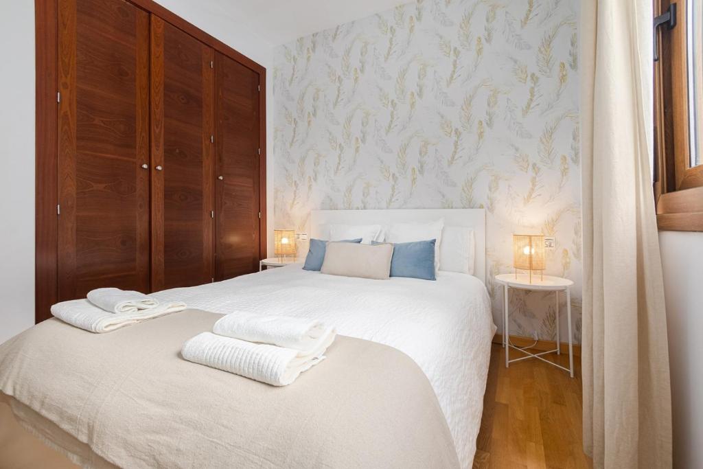 ein Schlafzimmer mit einem weißen Bett und Handtüchern darauf in der Unterkunft AGUA 21 in Málaga