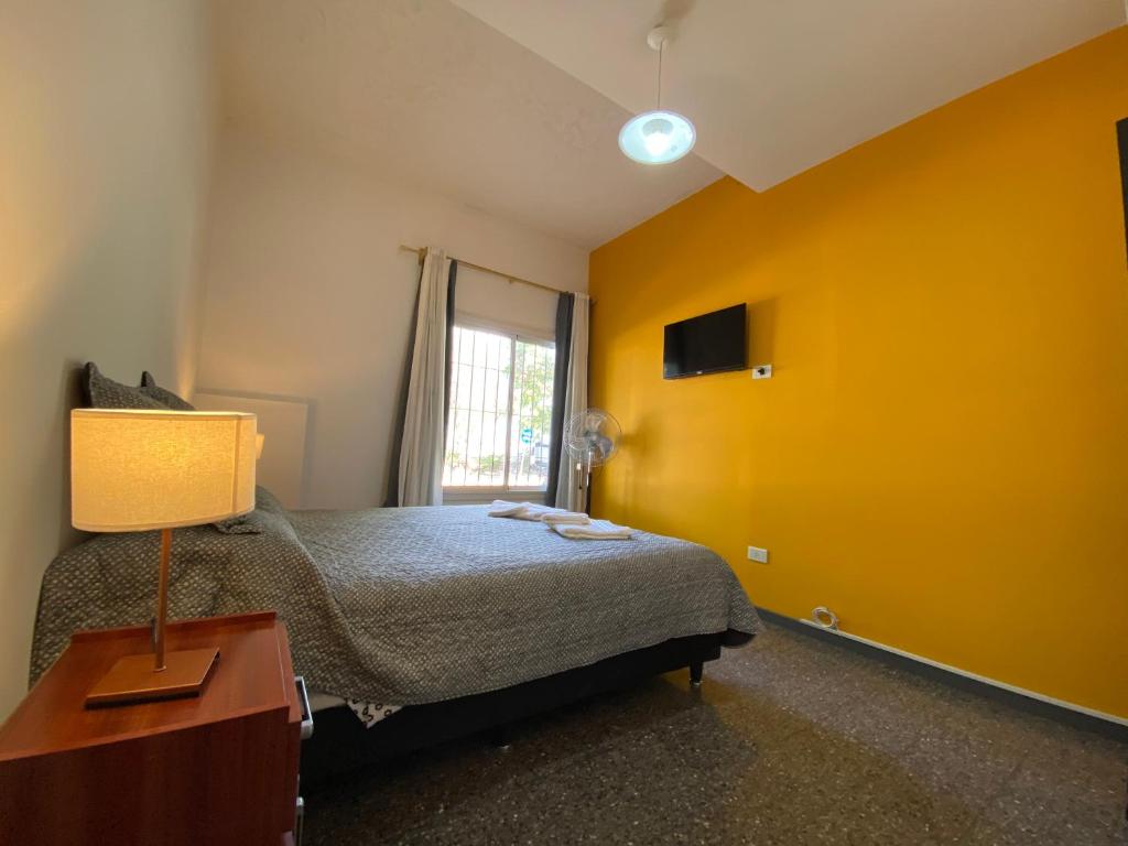1 dormitorio con cama y pared amarilla en departamento godoy cruz en Godoy Cruz