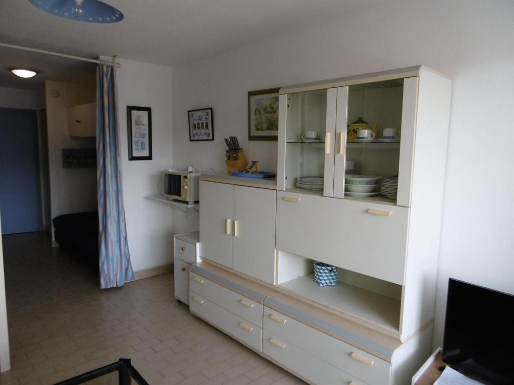 kuchnia z białą szafką z naczyniami w obiekcie Appartement 5 pers avec loggia, parking privé à Sète - FR-1-472-166 w mieście Sète