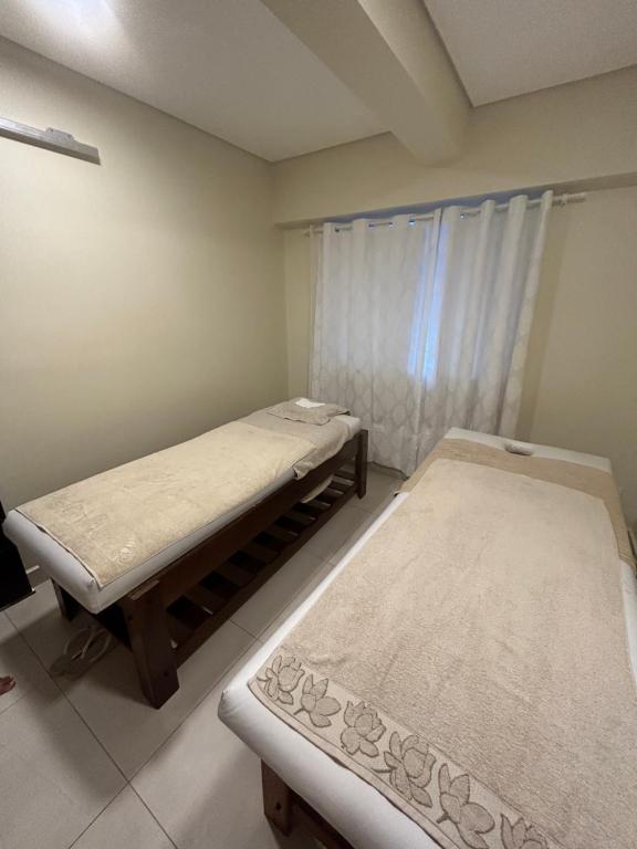 2 Betten in einem Zimmer mit Fenster in der Unterkunft SALINAS PARK RESORT in Salinópolis