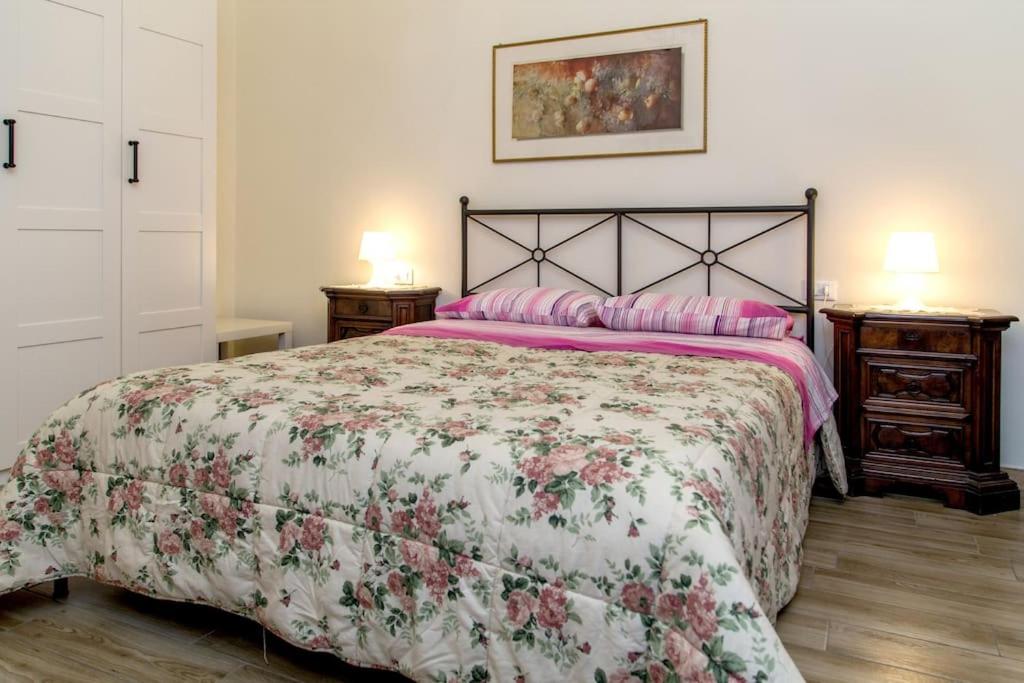 a bedroom with a bed with a floral bedspread at Appartamento Cosimo in Florence