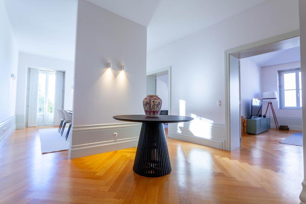 a room with a table with a vase on it at The Palace Penthouse in Porto