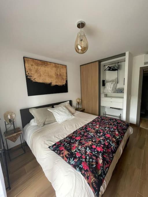 sypialnia z łóżkiem z kwiatowym kocem w obiekcie Appartement calme proche Bastia w mieście Cardo