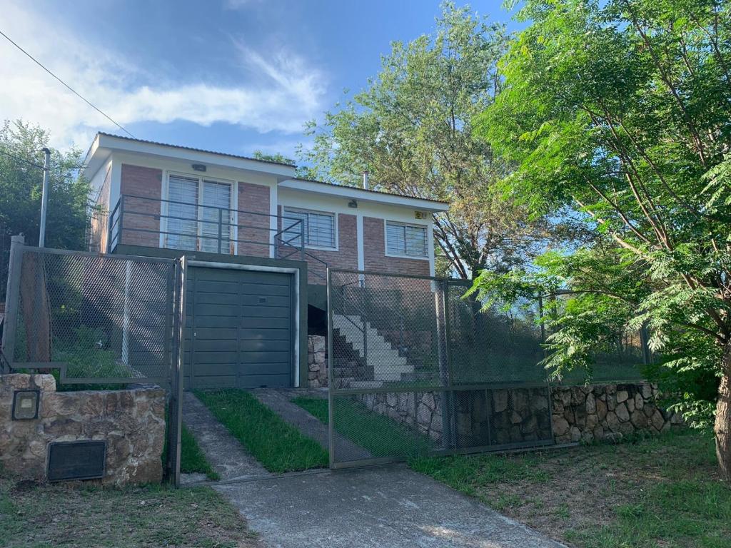 una casa con una valla delante de ella en Chalet frente al Balneario en Villa Carlos Paz