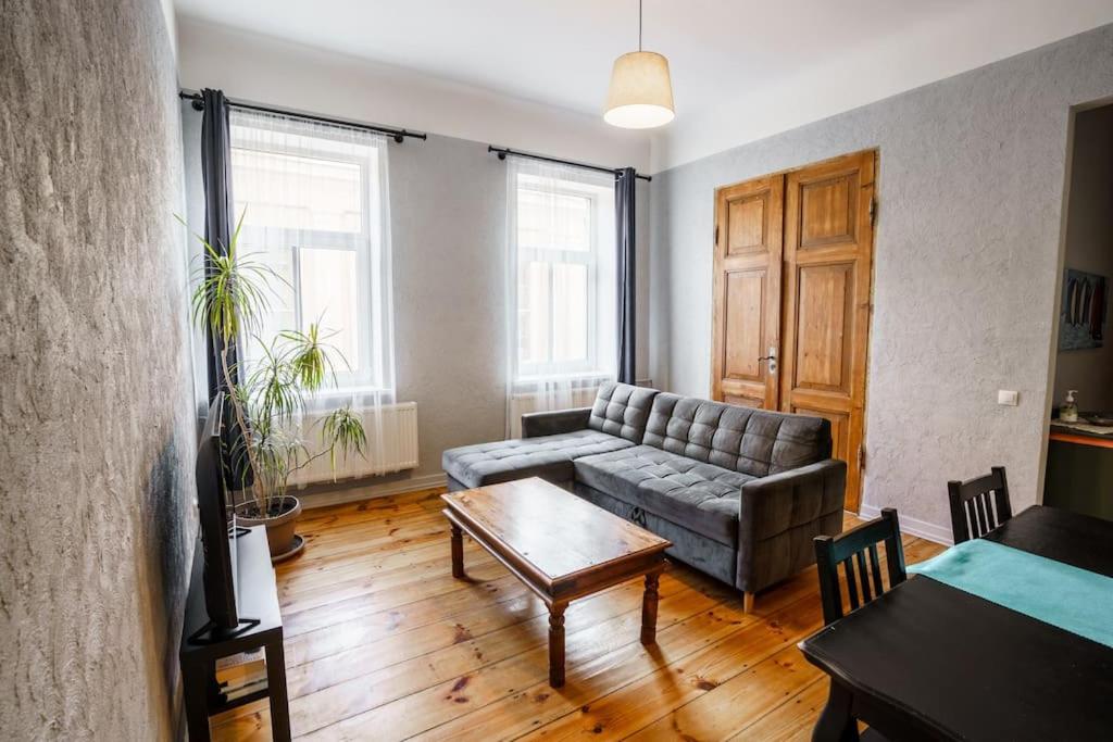 een woonkamer met een bank en een tafel bij Two bedroom Ausekla apartment in Liepāja