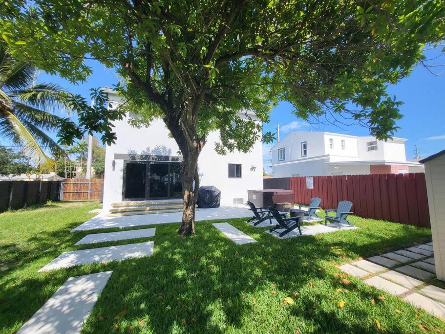 un arbre dans une cour avec une table et des bancs dans l'établissement Rockland Villa - Huge in the epicenter of Miami, à Miami