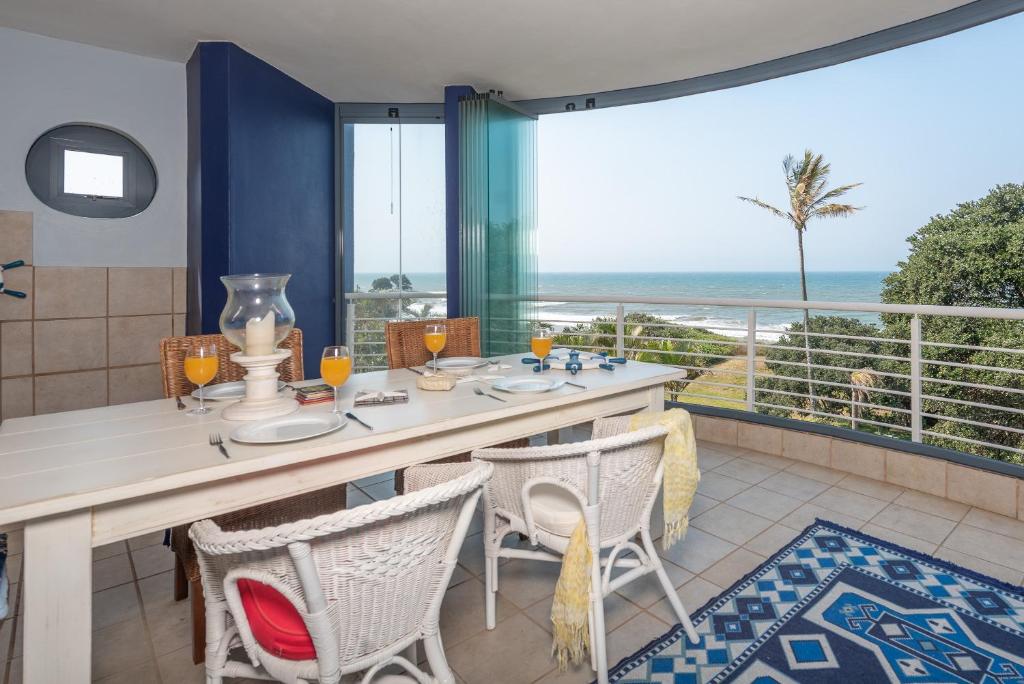 a dining room with a table and chairs and a balcony at INDIGO BAY 24 in Margate