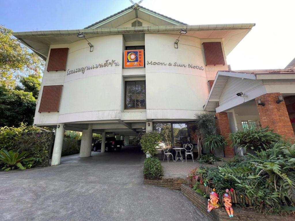 a large white building with a patio in front of it at โรงแรมมูนแอนด์ซัน Moon and Sun Hotel in Chiang Rai