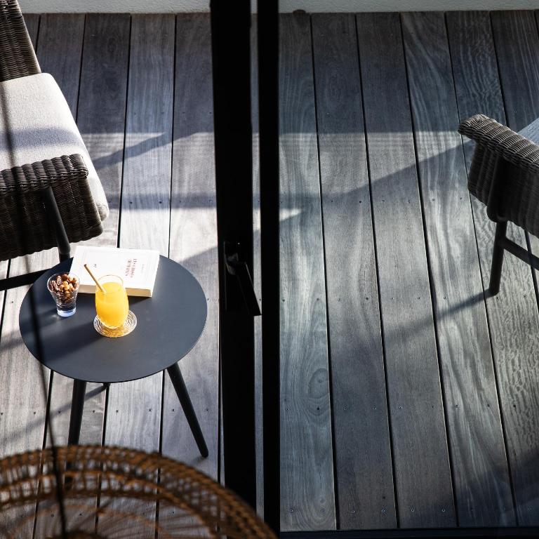 a glass of orange juice on a table on a deck at Le Celtique & Spa in Carnac