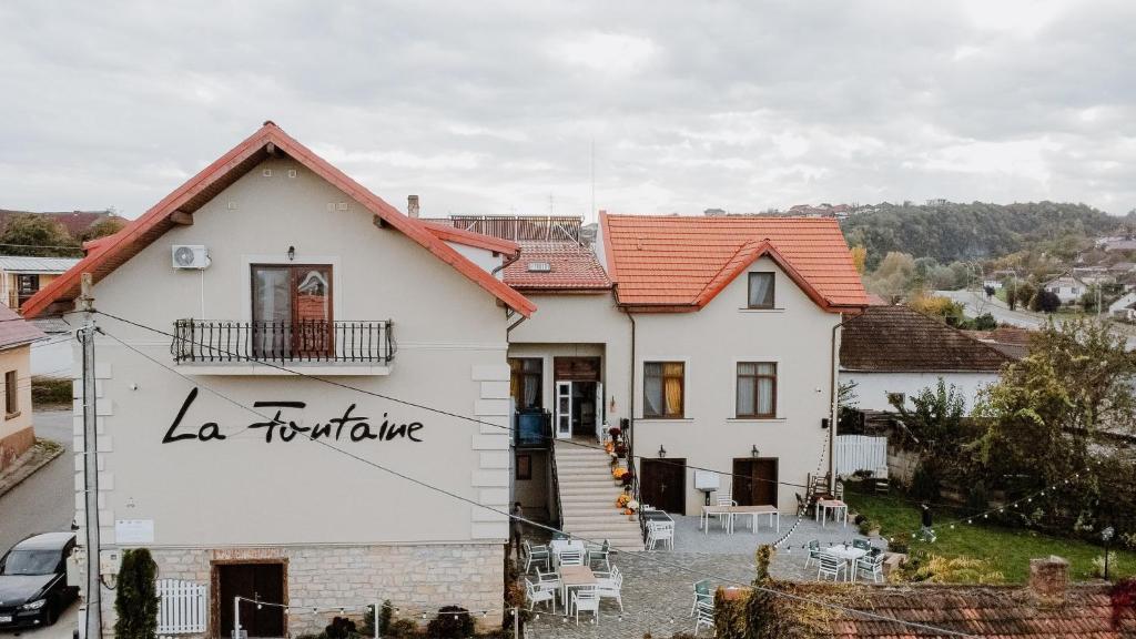 une maison blanche avec un toit rouge dans l'établissement La Fontaine, à Hunedoara