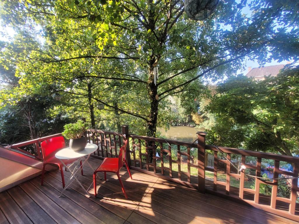 una terrazza in legno con tavolo e sedie. di studio 50m2 au bord de l'eau à STRASBOURG a Strasburgo