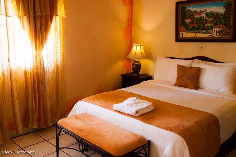 a hotel room with two beds and a window at Hotel Camino Maya in Copan Ruinas