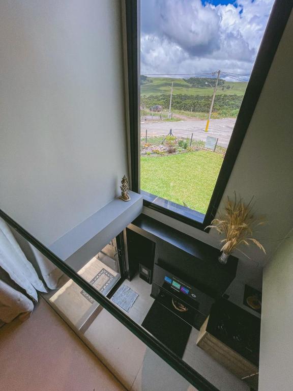 a room with a large window with a desk at Tiny House Cambará in Cambará