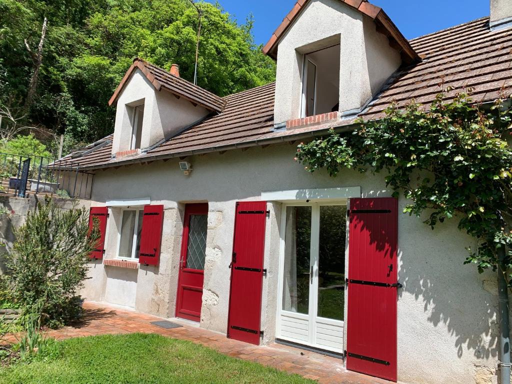une maison avec des portes rouges sur son côté dans l'établissement Au Coeur des Châteaux, à Chambon-sur-Cisse