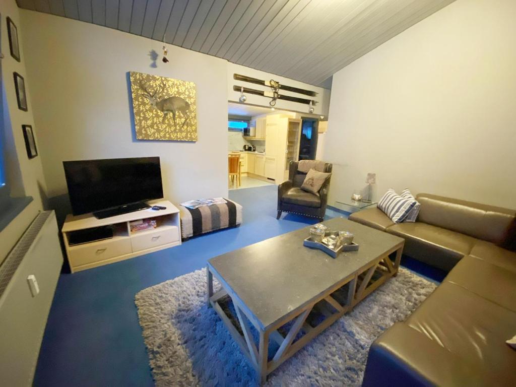 St Anton ski apartments في سانكت أنتون ام ارلبرغ: غرفة معيشة مع أريكة وطاولة