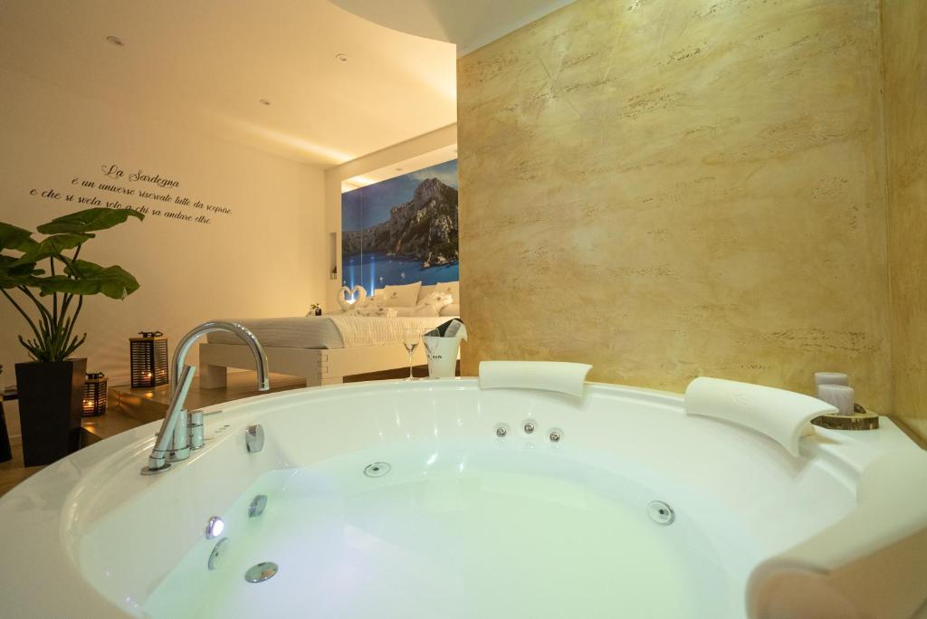 a bath tub in a room with a wall at Sunshine Charming Houses in Alghero
