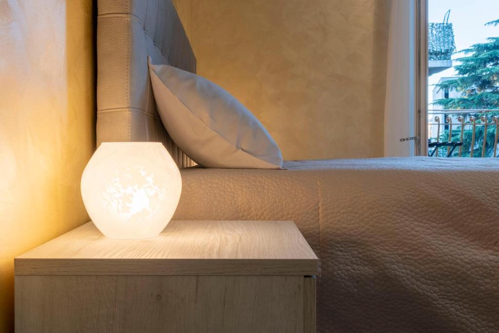 lampa siedząca na łóżku obok okna w obiekcie Leader Apartment 4 w Mediolanie