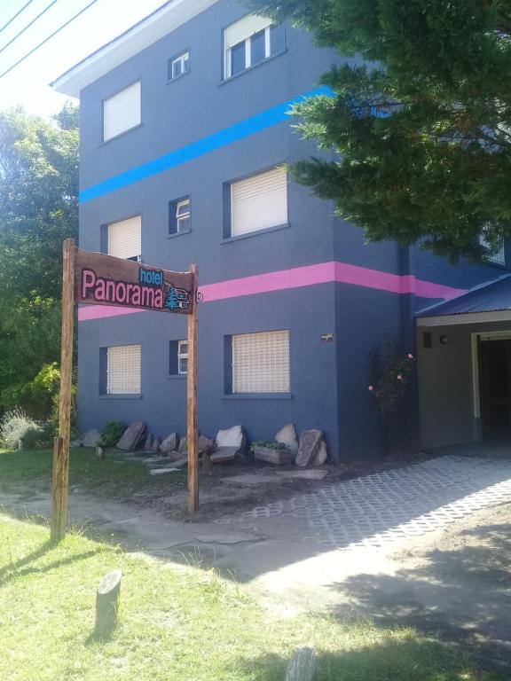 un edificio azul con un cartel delante en Panorama Villa Gesell en Villa Gesell