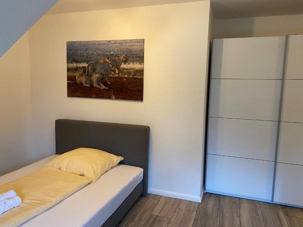 a bedroom with a bed and a painting on the wall at Ferienwohnung Haus Ossenkopp in Dümmer
