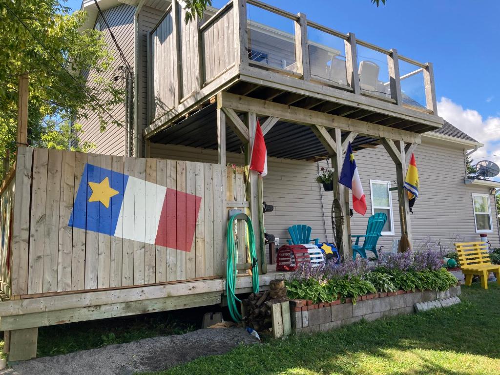 una casa con una terraza con una bandera. en Shediac Beachfront, en Shediac