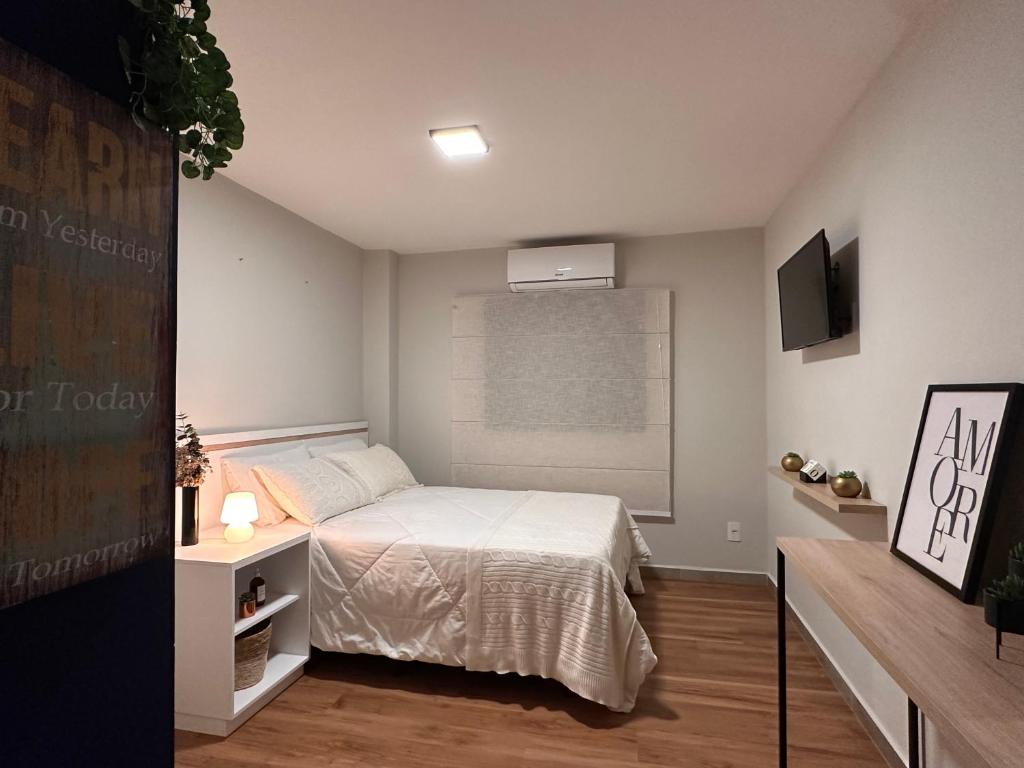 um pequeno quarto com uma cama e uma televisão em Apê Bela Vista Major em São Paulo