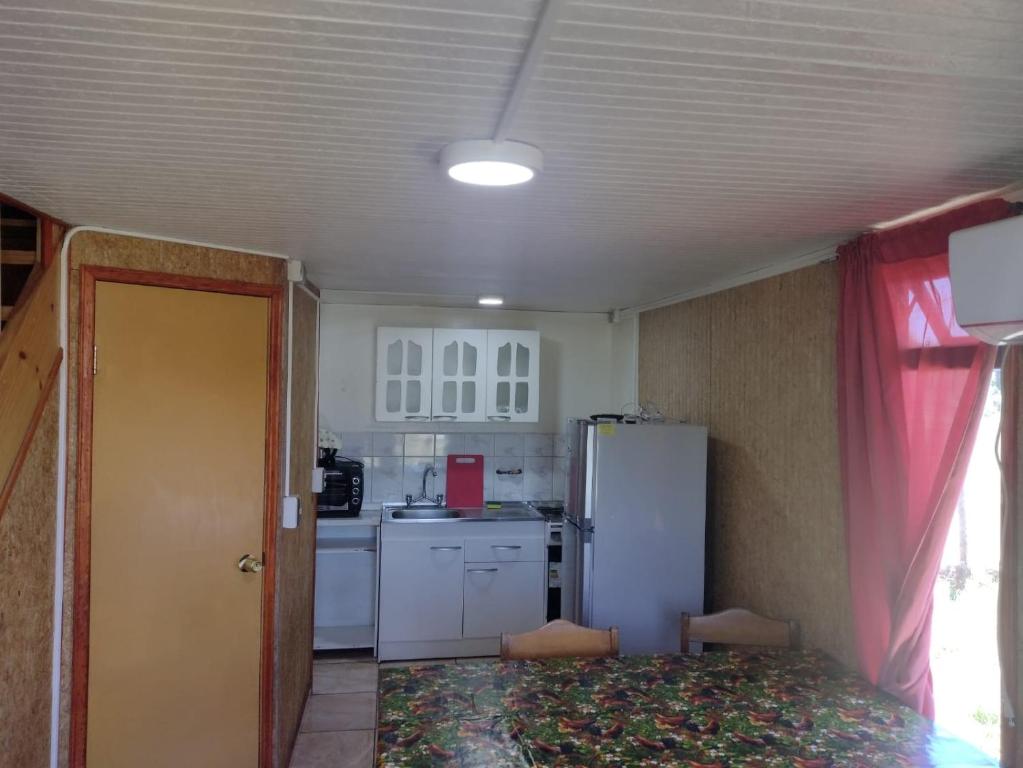 eine kleine Küche mit einem weißen Kühlschrank und einem Fenster in der Unterkunft Departamento Rayen Karu in Puerto Montt