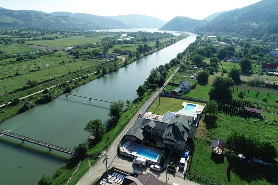 una vista aerea di una casa accanto a un fiume di Pensiunea Lory a Piatra Neamţ