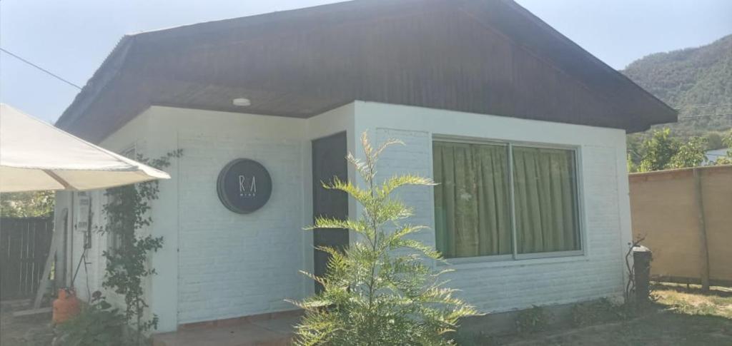 a small white house with a black roof at Casa Ruka-Yáquil de Nancagua, completamente amoblada. in Nancagua