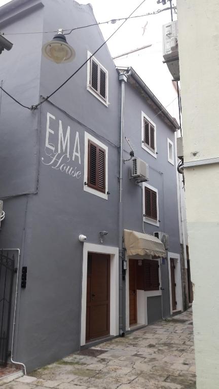 un edificio gris con un cartel en el costado en APARTMANI EMA, en Zadar