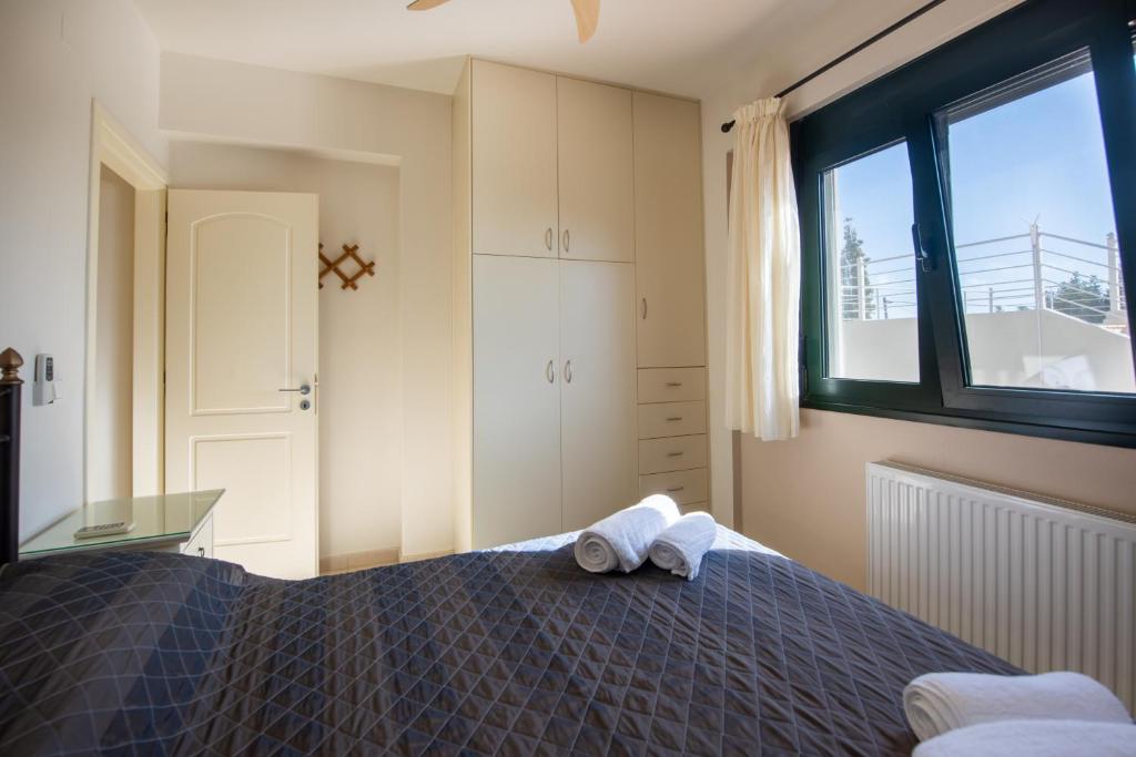 a bedroom with a bed with a towel on it at Portela Apartments Kampoula in Keratokampos