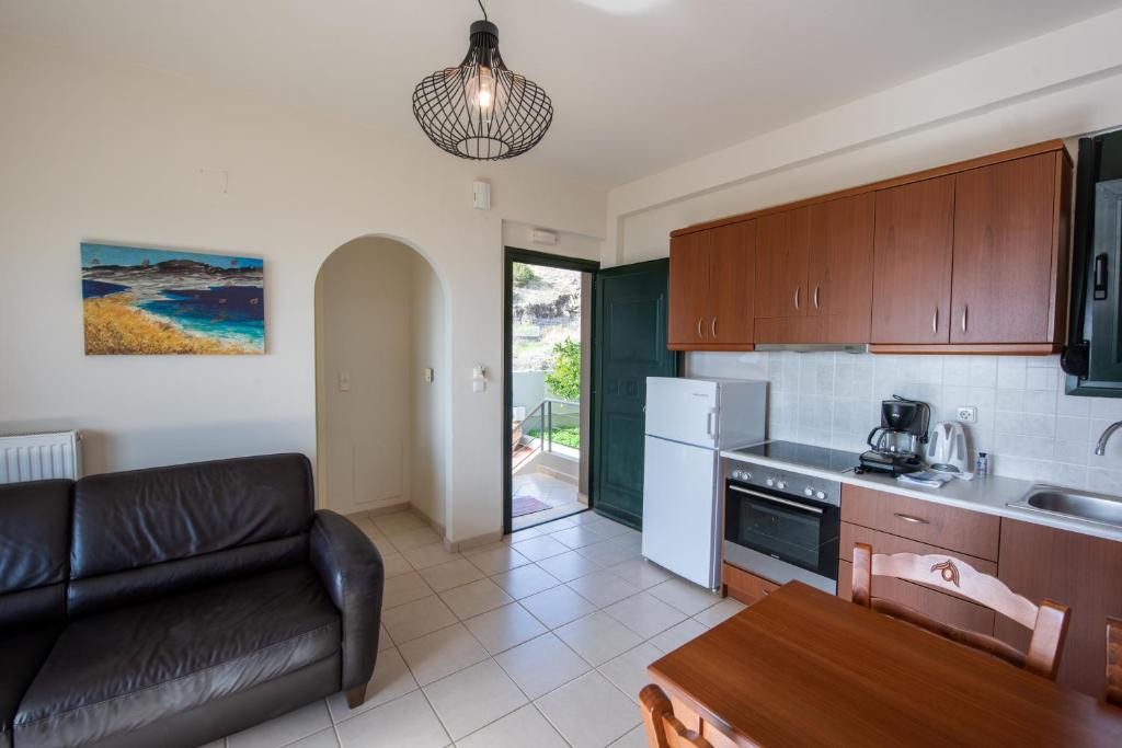 a kitchen with a couch and a table in a room at Portela Apartments Kampoula in Keratokampos