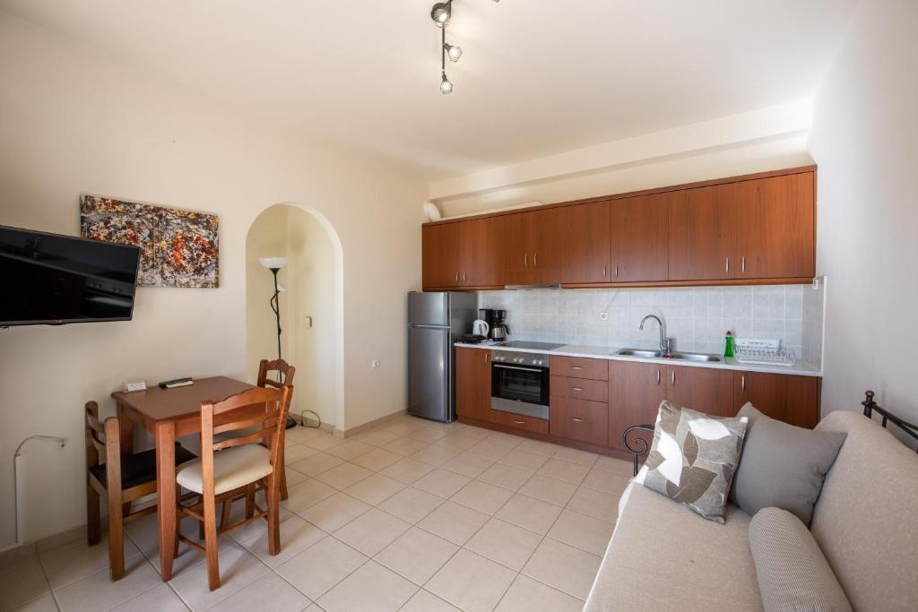 a living room with a couch and a table and a kitchen at Portela Apartments Kampoula in Keratokampos