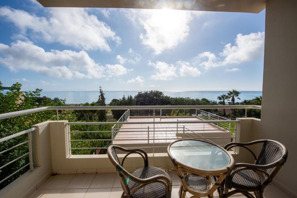 a balcony with two chairs and a glass table at Portela Apartments Kampoula in Keratokampos