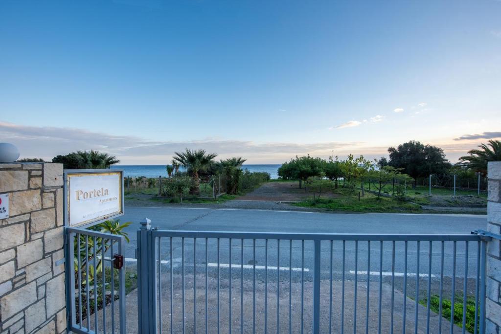 a gate in front of a road with the ocean at Portela Apartments Kampoula in Keratokampos