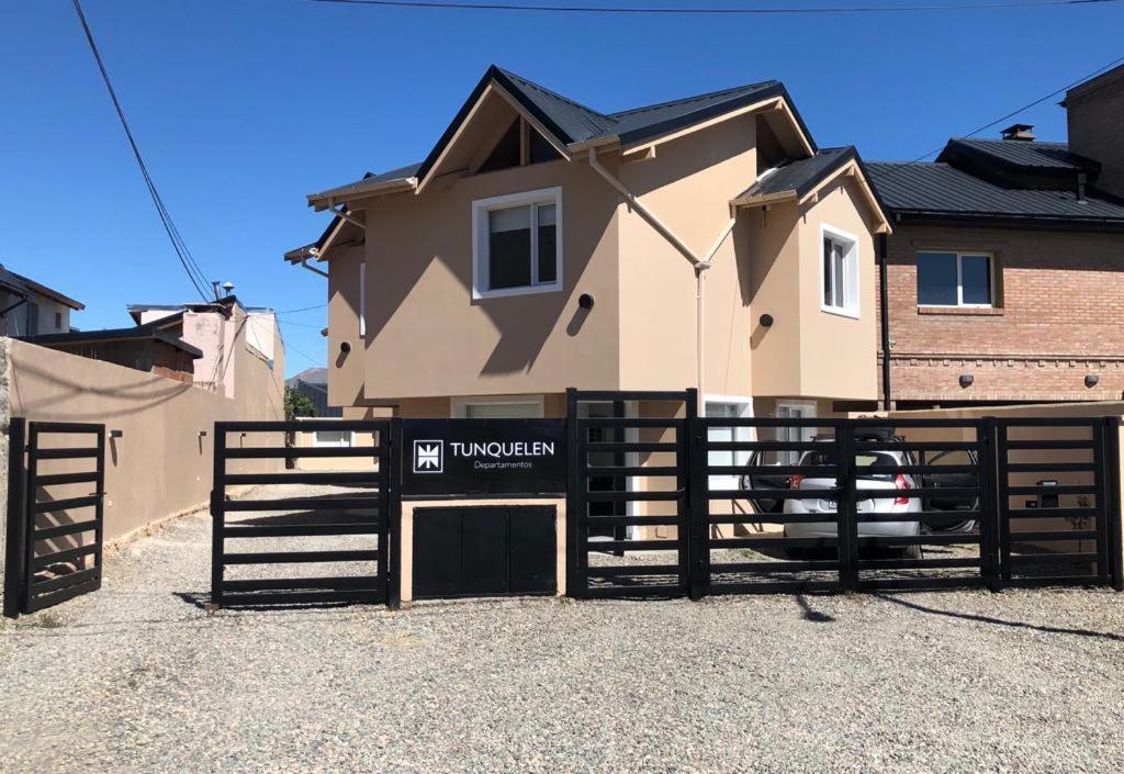 a fence with a sign in front of a house at Departamento Tunquelen in Esquel