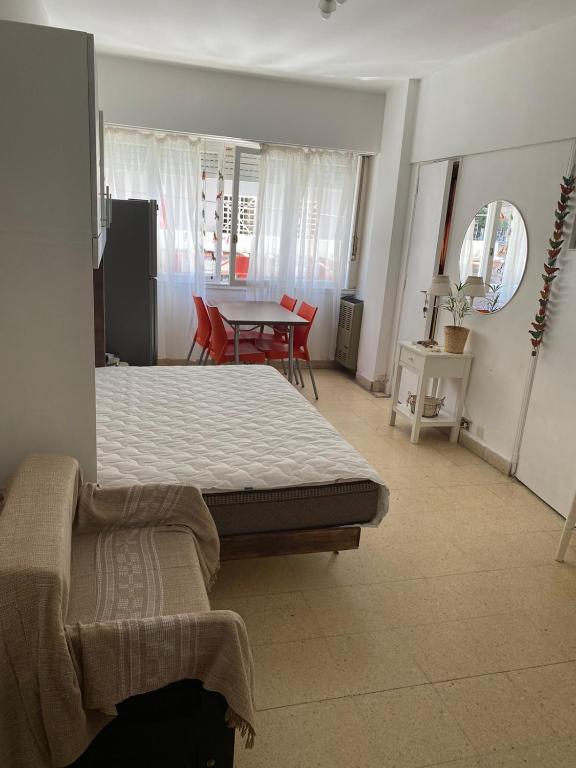 una camera con letto, tavolo e sedie di departamento monoambiente a Mar del Plata