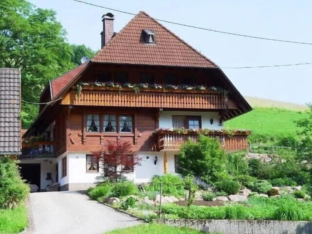 uma casa com telhado de palha e uma entrada em Lovingly furnished holiday apartment in our Black Forest house em Gutach