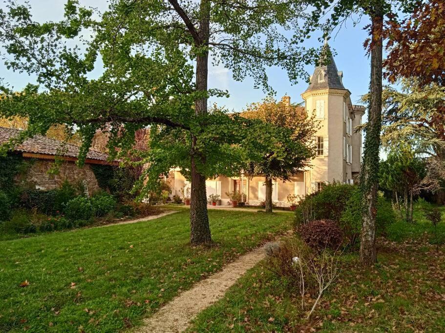 una casa con un árbol y un camino delante de él en Maison calme avec piscine entourée de son parc, en Quintenas