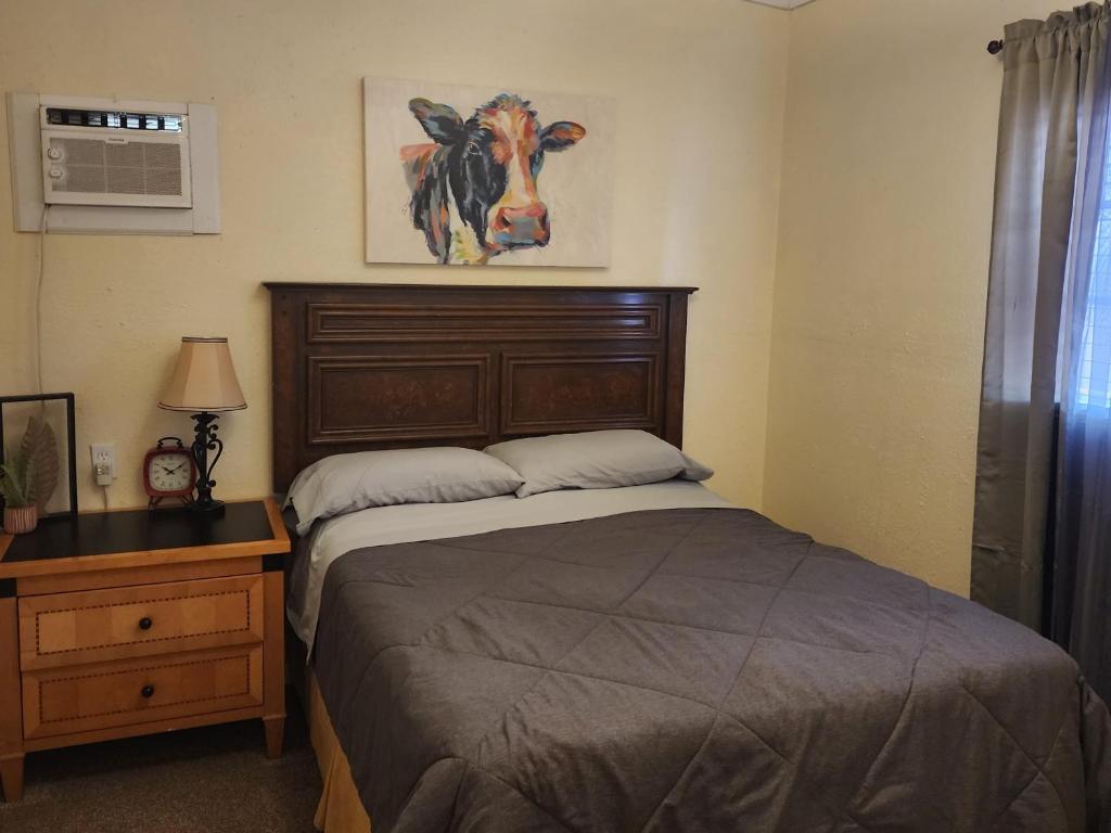 a bedroom with a bed with a cow picture on the wall at Dolan Springs, Grand Canyon Skywalk in Dolan Springs